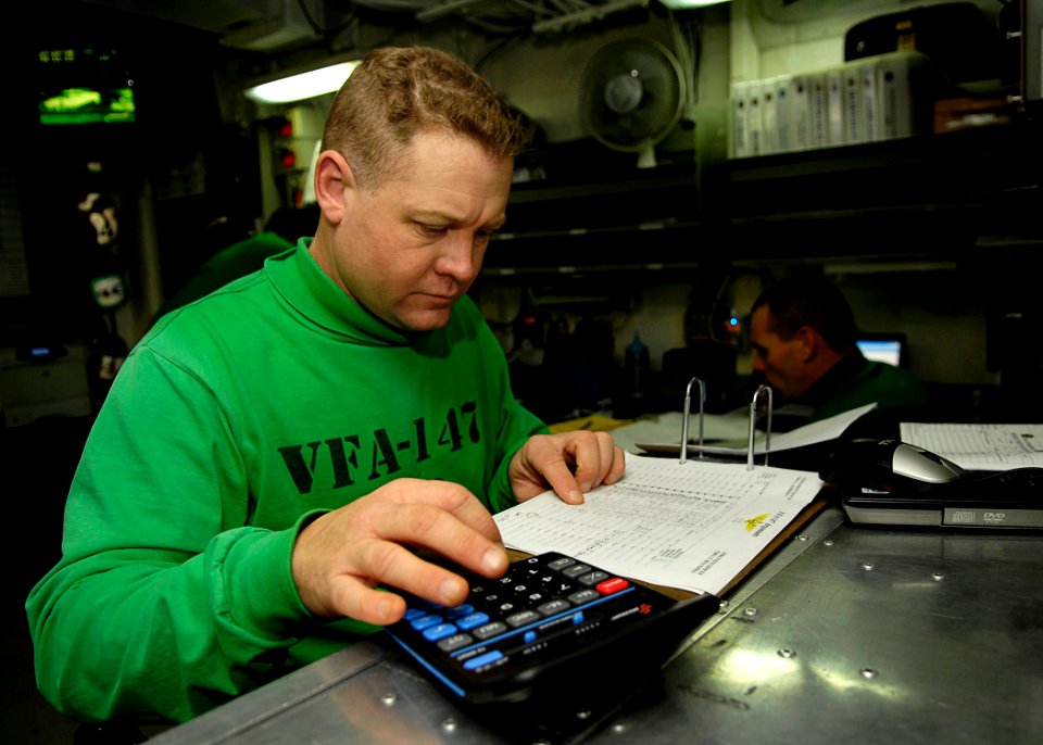US Navy 081029-N-4954I-002 Chief Aircrew Survival Equipmentman Rob Ramsey calculates flight times