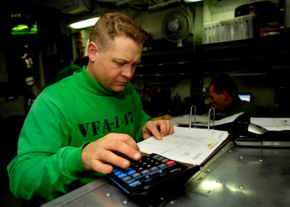 US Navy 081029-N-4954I-002 Chief Aircrew Survival Equipmentman Rob Ramsey calculates flight times