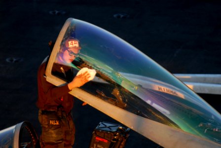 US Navy 081103-N-1635S-004 Aviation Electrician's Mate Airman Benjamin Olegario cleans the canopy of an F-A-18C Hornet assigned to the