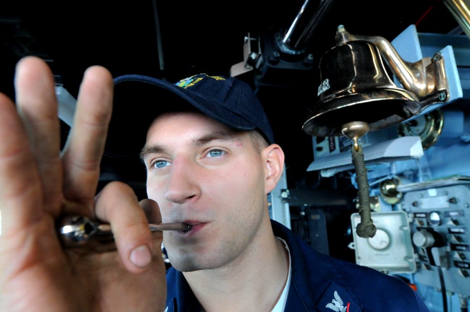 US Navy 081028-N-9774H-010 Boatswain's Mate 3rd Class Adam Parrot pipes over the 1MC in preparation for an announcement from the bridge aboard the amphibious assault ship USS Kearsarge (LHD 3)
