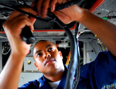 US Navy 081029-N-9689V-002 viation Electrician's Mate 3rd Class Christopher Houston re-attaches a distributor harness to the environmental control system of an MH-60S Sea Hawk helicopter