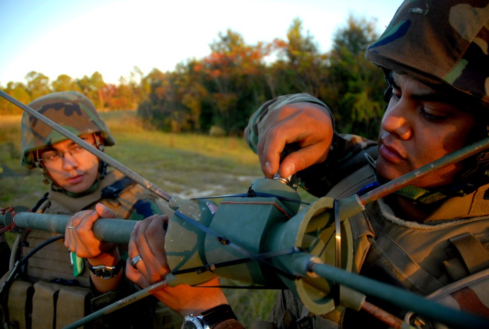 US Navy 081103-N-7367K-009 Construction Electrician 3rd Class Noe Lujan, right, and Construction Electrician 2nd Class Anthony Arcilla, both assigned to Naval Mobile Construction Battalion (NMCB) 1, erect an OE-254 antenna
