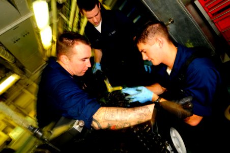 US Navy 081028-N-7918H-064 Aviation Ordnanceman 2nd Class Doug Davis, Aviation Ordnanceman Airman James Ballard and Aviation Ordnanceman Airman Dustin Biri conduct maintenance on an M61 A1 gun