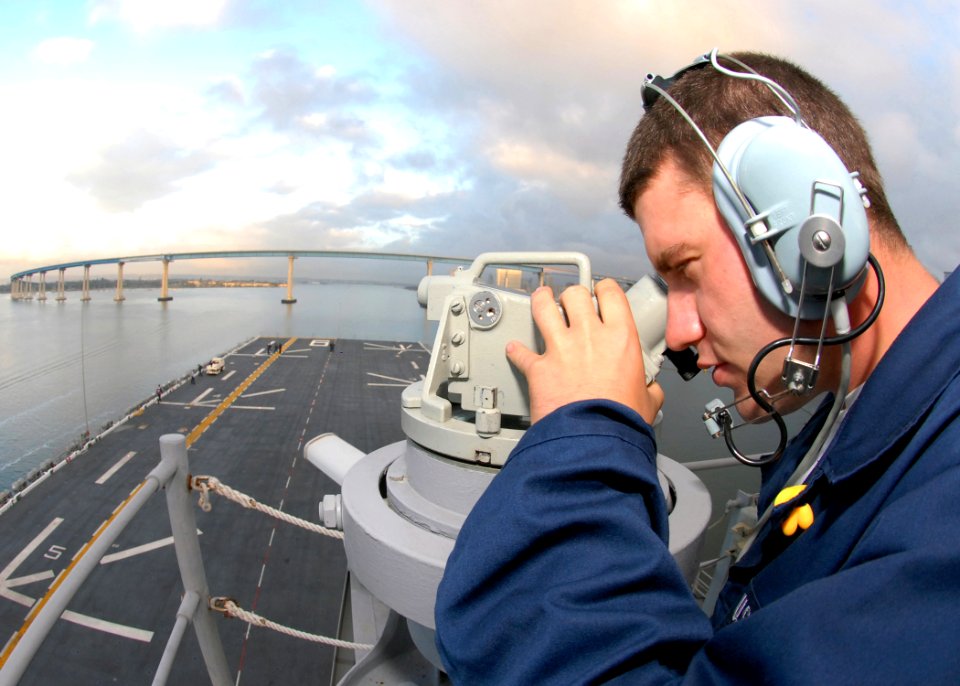 US Navy 081103-N-0998G-014 Quartermaster Seaman Tom Vest uses an alidade navigation device to relay bearings-from-land readings to the quartermasters