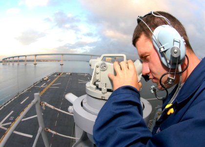 US Navy 081103-N-0998G-014 Quartermaster Seaman Tom Vest uses an alidade navigation device to relay bearings-from-land readings to the quartermasters