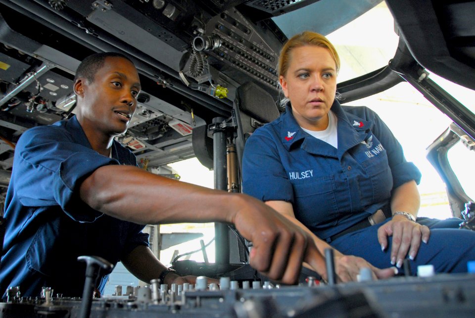 US Navy 081029-N-9689V-001 Aviation Electrician's Mate 1st Class Edwin Berryman and Aviation Electronics Technician 2nd Class Shery Hulsey perform routine maintenance in the cockpit of an MH-60S Sea Hawk