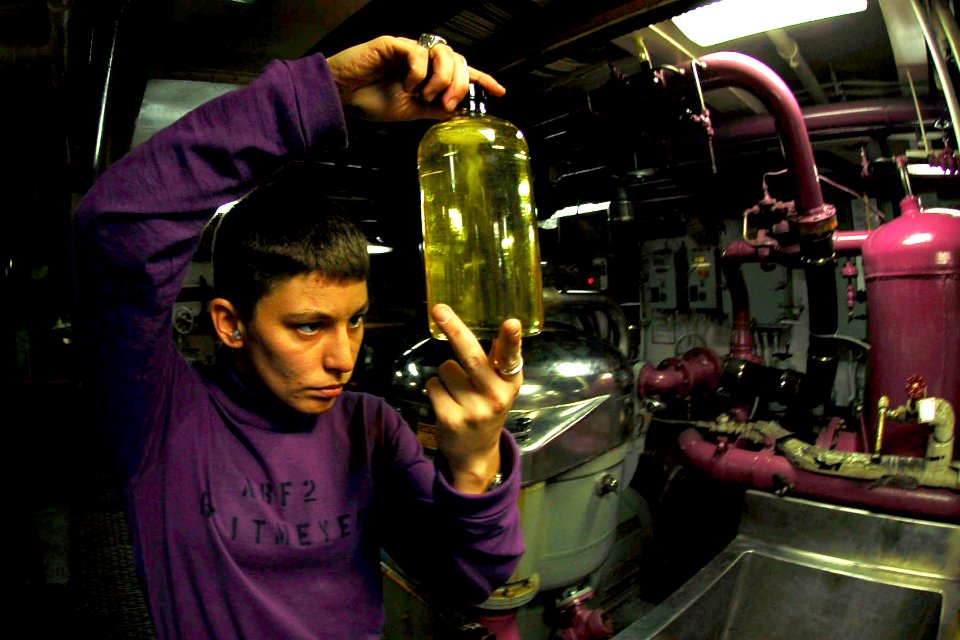 US Navy 081103-N-6538W-052 Aviation Boatswain's Mate (Fuel) 2nd Class Lea Reitmeyer, from Lock Haven, Pa., examines a JP-5 fuel sample for clarity in an aviation fuels pump room aboard the Nimitz-class aircraft carrier USS John