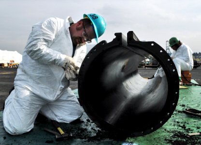 US Navy 081030-N-7981E-065 Darren Schmittler cleans a section of a steam-powered catapult track aboard the aircraft carrier USS Abraham Lincoln (CVN 72) during maintenance at Puget Sound Naval Shipyard