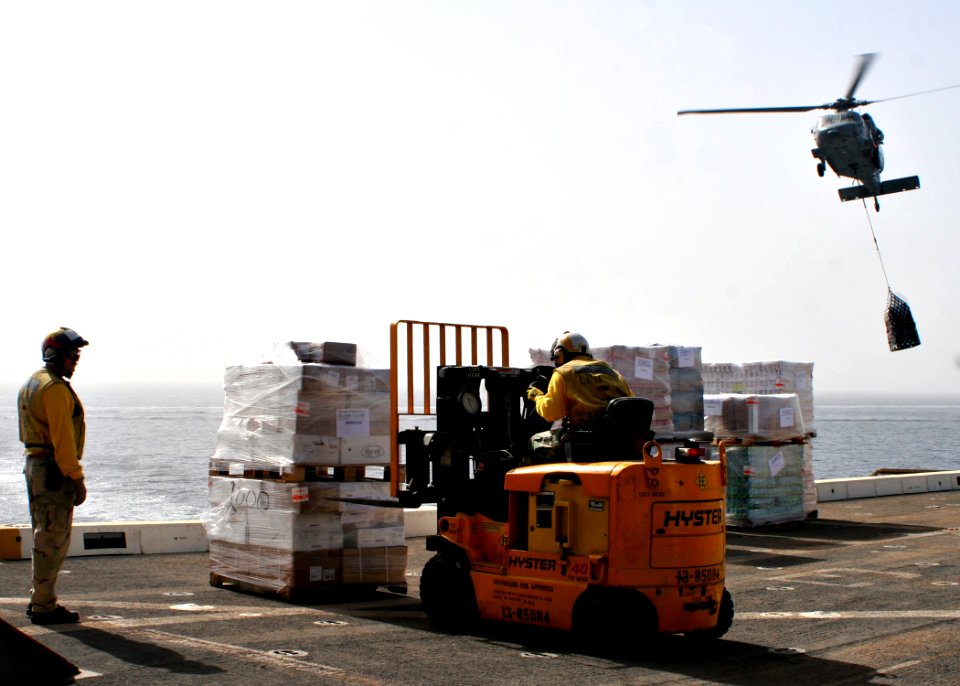 US Navy 090214-N-6764G-058 Sailors move pallets of supplies delivered by an MH-60S Sea Hawk