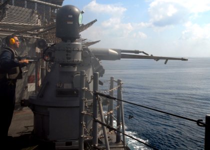 US Navy 081107-N-9900B-003 Gunner's Mate 2nd Class Michael Finch test-fires a 25mm gun aboard the guided-missile cruiser USS Monterey (CG 61)