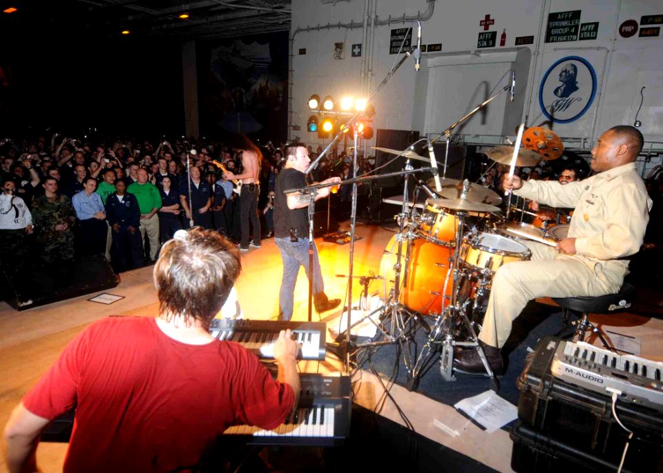 US Navy 081104-N-9565D-043 Command Master Chief Jeffery C. Clarke plays the drums during a performance with the rock group Smash Mouth