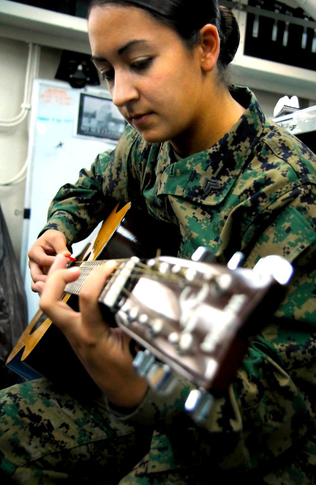US Navy 081102-N-4774B-114 Sgt. Gabby Reynoso performs chord progression rhythms on a guitar