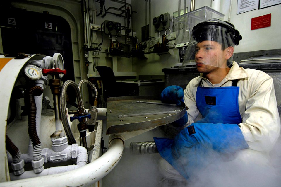 US Navy 081103-N-4954I-027 Machinist's Mate 3rd Class Samuel Strasser fills a liquid oxygen cart