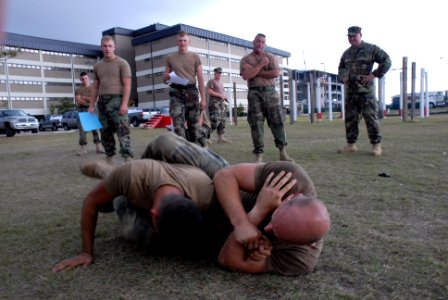 US Navy 081106-N-1057H-215 CM2 Aaron Wymore, Marine Corps Mixed Martial Arts Program (MCMAP) instructor for NMCB-11, grapples with EO3 Elliot Bunek, an MCMAP student from NMCB 74, during the training's final evolution while oth