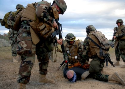 US Navy 081106-N-3857R-012 Seabees assigned to the Naval Mobile Construction Battalion (NMCB) 1 quick reaction force secure a hostile camp intruder with zip ties