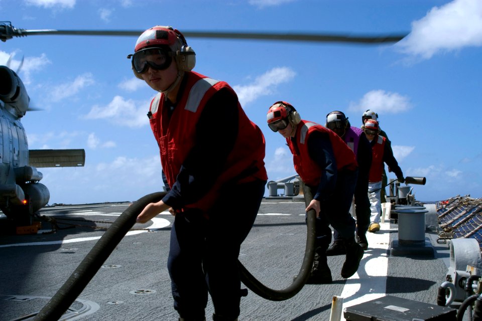 US Navy 081106-N-9123L-003 Electrician's Mate Fireman Young Jun, from Jacksonville, Fla., guides a fuel hose after completing a