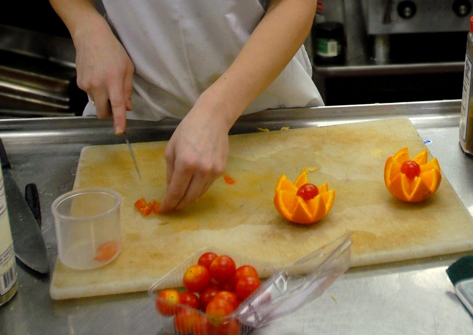 US Navy 081107-N-9132C-042 Culinary Specialist Seaman Jessica Menz, from Minn., carves an orange and cherry tomatoes into a fruit sculpture in the Chief Petty Officer's Mess aboard the Nimitz-class aircraft carrier USS Ronald R