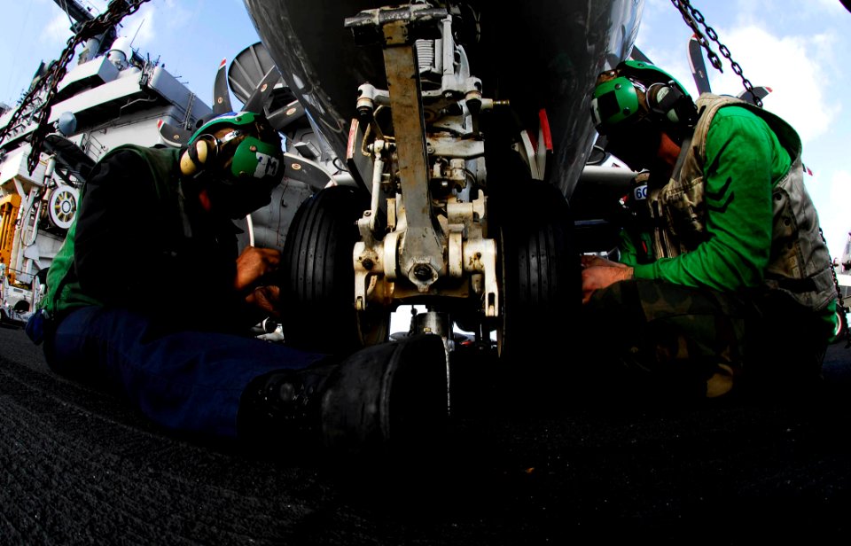 US Navy 081109-N-9928E-062 Aviation Structural Mechanic 3rd Class Luis Cardozo-Gonzalez nd Aviation Structural Mechanic 2nd Class Randy Roller replace a nose wheel tire on an E-2C Hawkeye