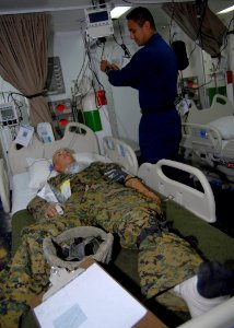 US Navy 081105-N-9150R-051 Amphibious assault ship USS Boxer (LHD 4) Hospital Corpsman 1st Class Raul Huerta attends to a Marine with a simulated lower leg amputation in the intensive care ward during a mass casualty drill