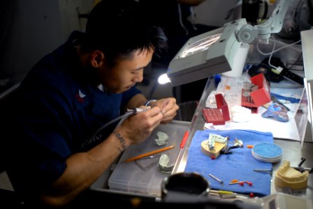 US Navy 081110-N-9132C-028 Hospital Corpsman 1st Class Noel Toledo, from Chula Vista, Calif., smoothes a crown in the dental lab aboard the Nimitz-class aircraft carrier USS Ronald Reagan (CVN 76) photo