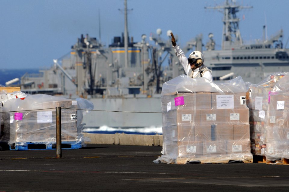 US Navy 081108-N-3659B-030 Chief Postal Clerk Mario Barco signals for a forklift to move supplies on the flight deck of the Nimitz-class aircraft carrier USS Ronald Reagan (CVN 76) during a vertical replenishment