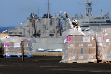 US Navy 081108-N-3659B-030 Chief Postal Clerk Mario Barco signals for a forklift to move supplies on the flight deck of the Nimitz-class aircraft carrier USS Ronald Reagan (CVN 76) during a vertical replenishment