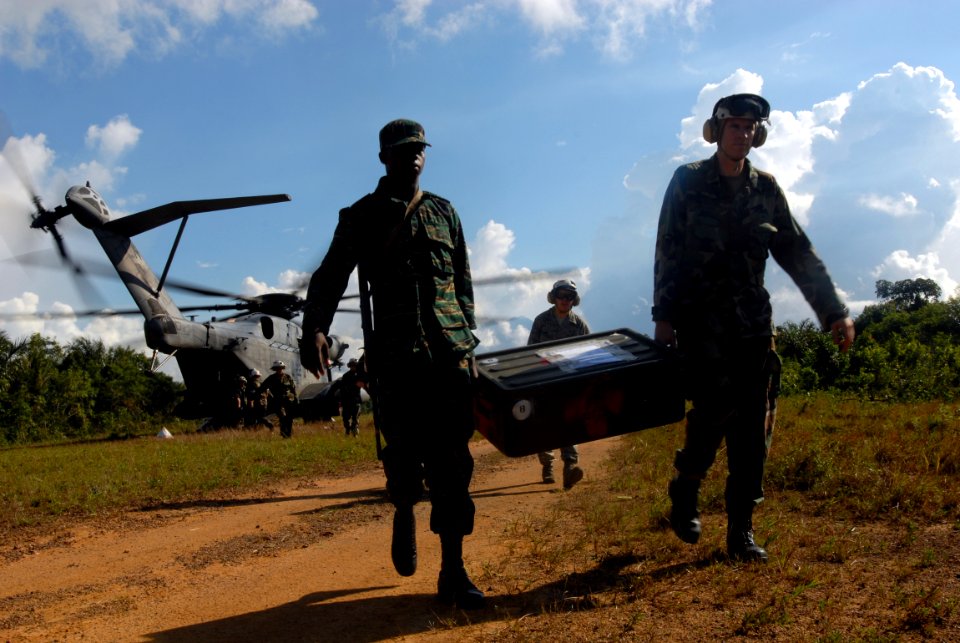 US Navy 081111-N-3595W-103 Lt. Cmdr. Nathan Uebelhoer and a member of the Guyana Defense Force, work together unloading medical supplies photo
