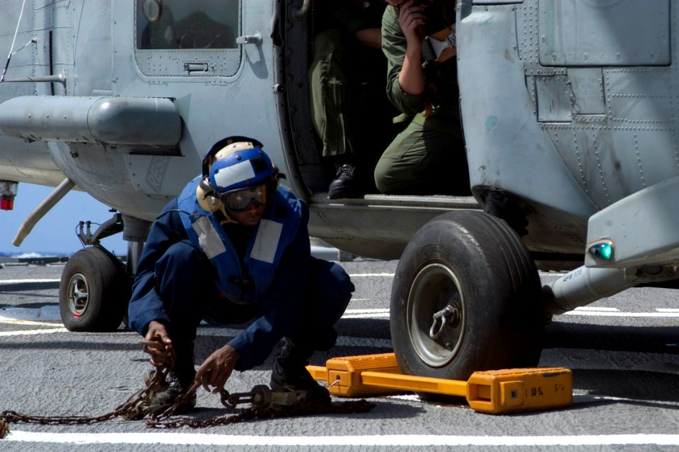 US Navy 081106-N-9123L-004 eaman Fredricko Jackson, from Bishopville, S.C., awaits instruction to remove the chock and chains from an SH-60 Sea Hawk helicopter
