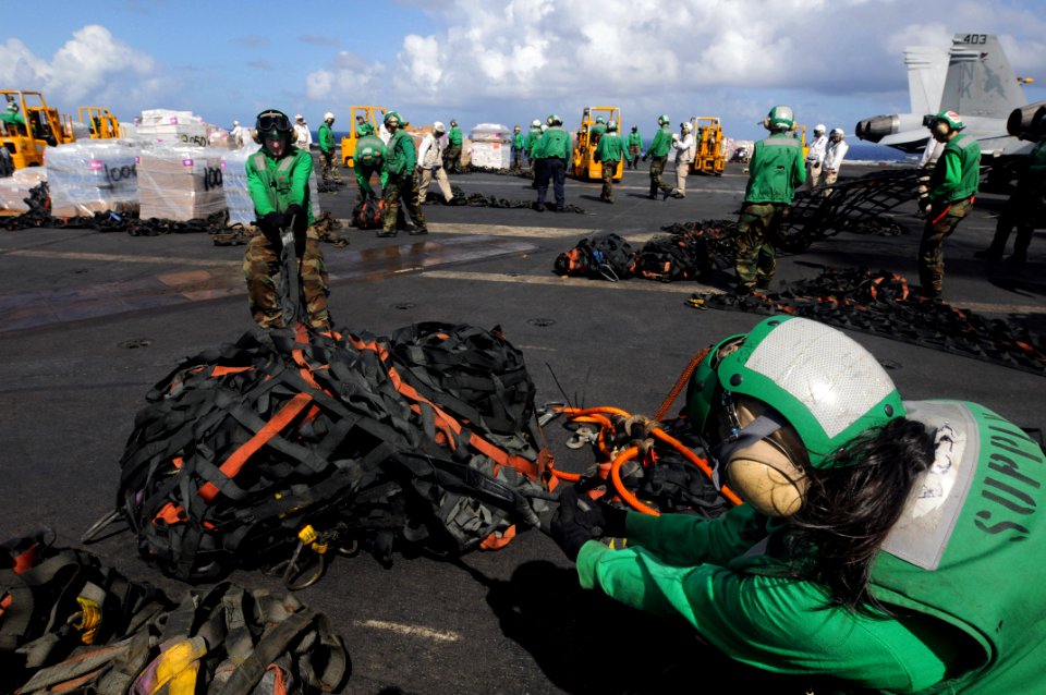 US Navy 081108-N-3659B-236 Storekeeper 3rd Class Rochelle Russell, right, and Storekeeper Seaman Brian Becker tie cargo nets in a bundle at the completion of a vertical replenishment