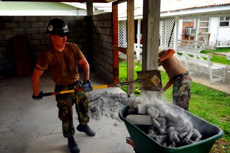 US Navy 081111-N-4515N-035 Builder 2nd Class Sean Roberts removes a broken block wall before starting construction work at a local hospital