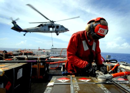 US Navy 081107-N-1038M-115 Aviation Ordnanceman Airman Jessica Jefferson attaches cables to a crate of ammunition as an MH-60S Sea Hawk