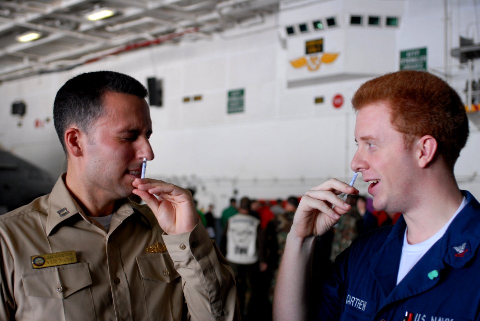 US Navy 081112-N-9132C-029 t. Sean Higgnbotham, left, and Machinist's Mate 2nd Class Lucas Carthew inhale a mist form of the flu vaccination aboard the Nimitz-class aircraft carrier USS Ronald Reagan (CVN 76)