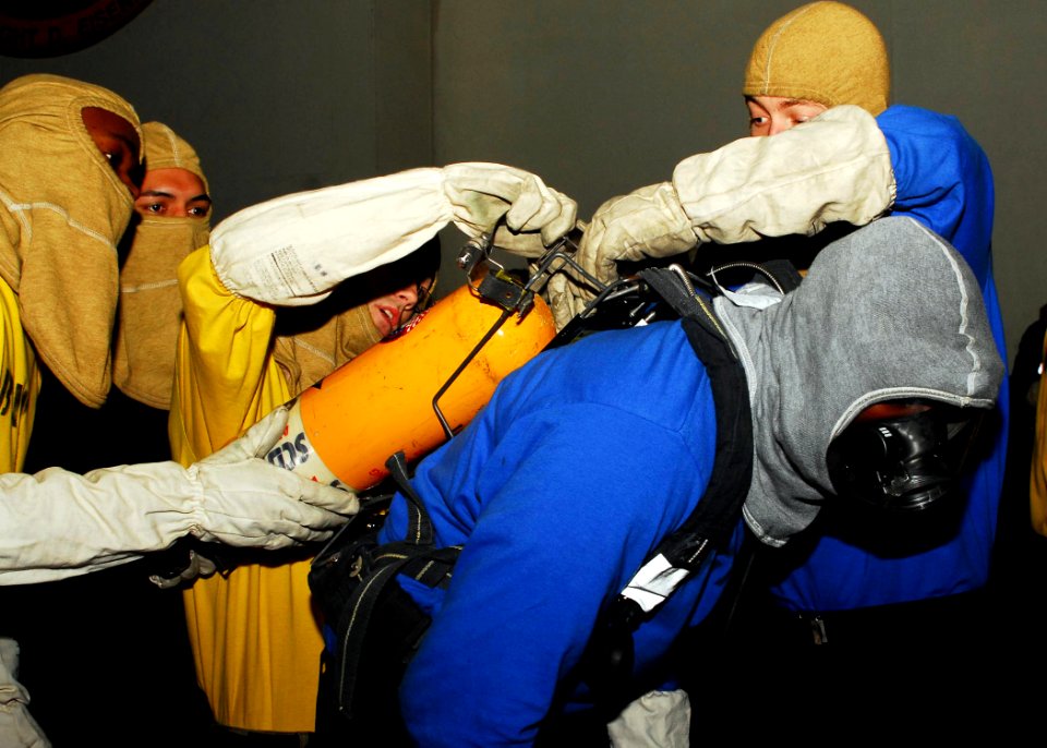 US Navy 081110-N-5033P-040 Sailors help a shipmate with his oxygen tank during a mass casualty drill
