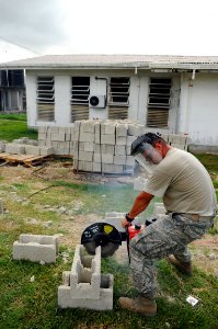 US Navy 081113-N-4515N-013 Air Force Staff Sgt. Richard Monsalve cuts cinder blocks to build a wall for a canteen at West Demarara Regional Hospital photo
