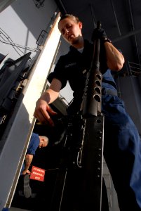 US Navy 081111-N-3610L-022 Aviation Ordnanceman Airman Ashley Ordorica prepares to hoist a .50 caliber machine gun to its mount