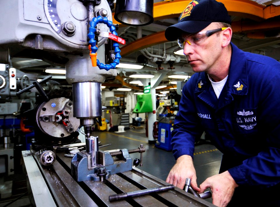 US Navy 091201-N-6003P-002 Machinery Repairman 1st Class Aaron Marshall modifies a socket on a milling machine