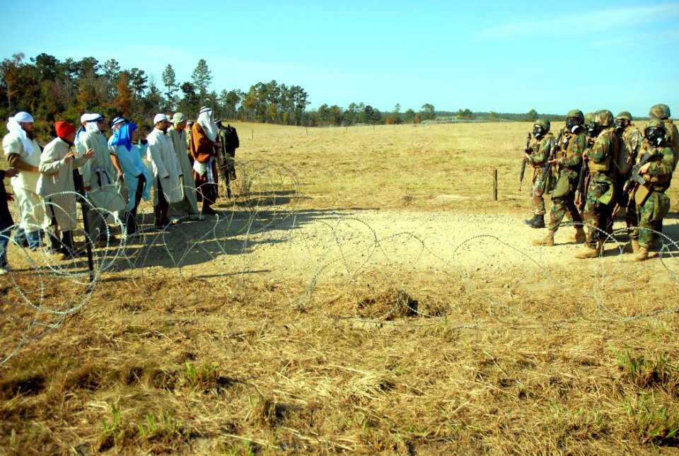 US Navy 081111-N-7367K-005 Seabees assigned to Naval Mobile Construction Battalion (NMCB) 1 stand by as a group of simulated insurgents gather at the entry control point of forward operating base 1