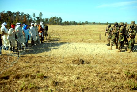 US Navy 081111-N-7367K-005 Seabees assigned to Naval Mobile Construction Battalion (NMCB) 1 stand by as a group of simulated insurgents gather at the entry control point of forward operating base 1