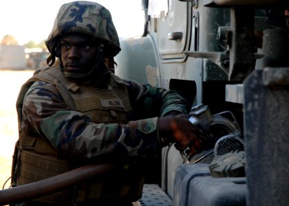 US Navy 081109-N-3857R-001 Equipment Operator 2nd Class Earnest Wilson, assigned to Naval Mobile Construction Battalion (NMCB) 1, fills his fuel tank before a convoy mission