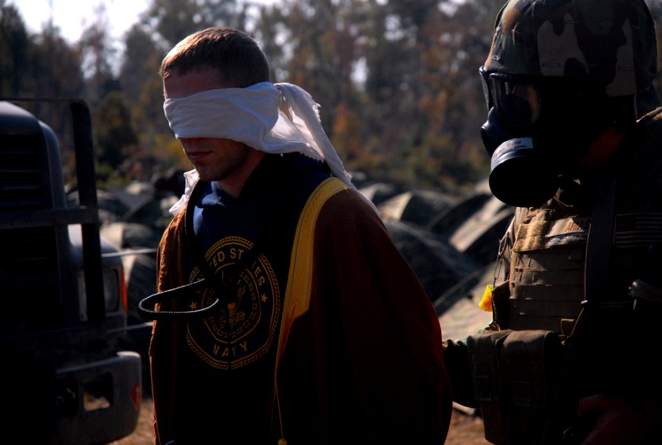 US Navy 081111-N-7367K-012 A simulated insurgent is blindfolded while being escorted to the enemy prisoners of war tent at forward operating base 1