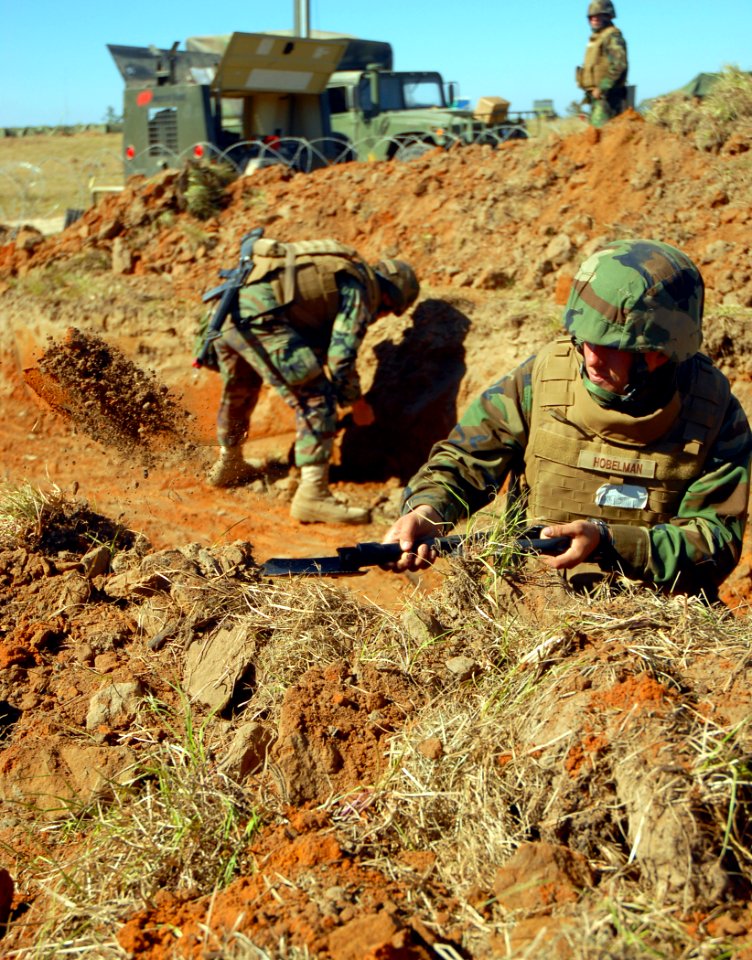 US Navy 081110-N-7367K-006 CMCR Joshua Hobelman, assigned to NMCB-1, tosses excess dirt from a hole that will be used as a timber bunker at forward operating base 1
