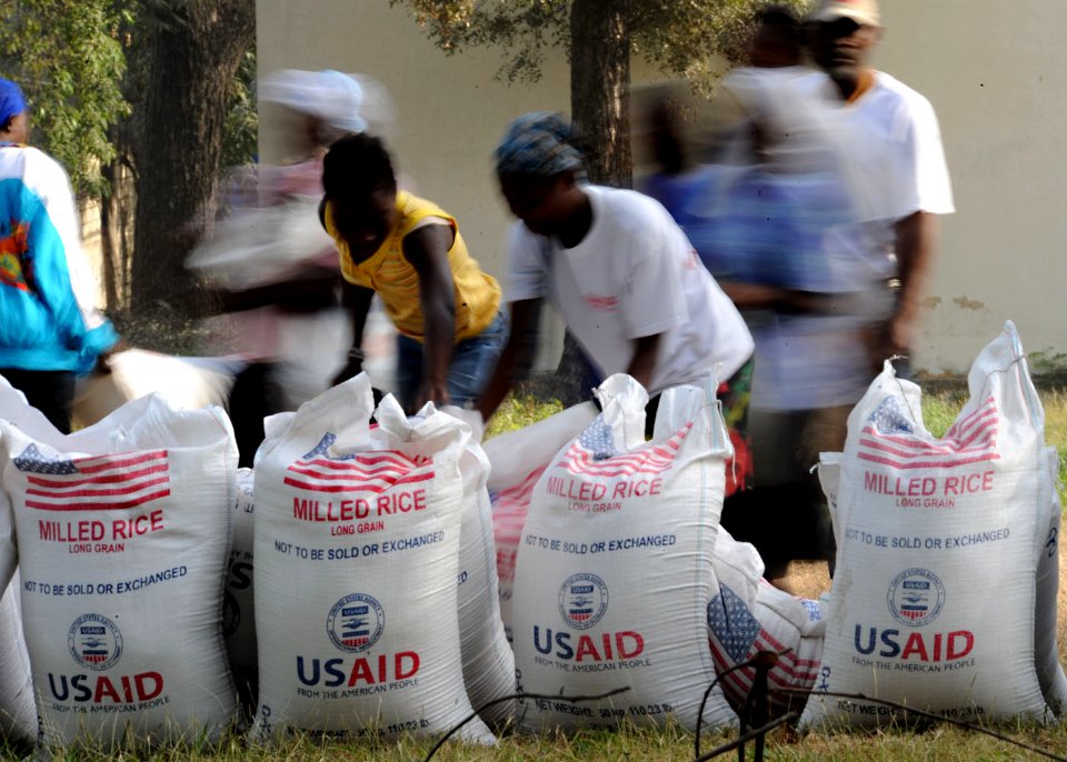 US Navy 100213-N-5961C-007 Haitian citizens take 100-pound bags of rice at an aid distribution point in Port-au-Prince, Haiti