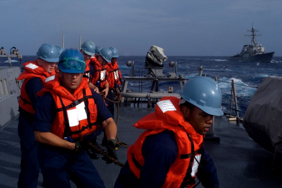 US Navy 081112-N-9123L-001 Line handlers aboard the guided-missile destroyer USS John S. McCain (DDG 56) haul in a line during an underway replenishment with the Military Sealift Command fleet replenishment oiler USNS John Eric