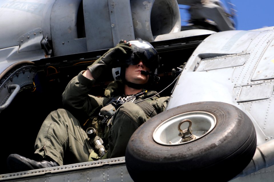 US Navy 081114-N-3659B-173 Naval Aircrewman 2nd Class Jeremy Thomas looks out the door of an SH-60F Sea Hawk
