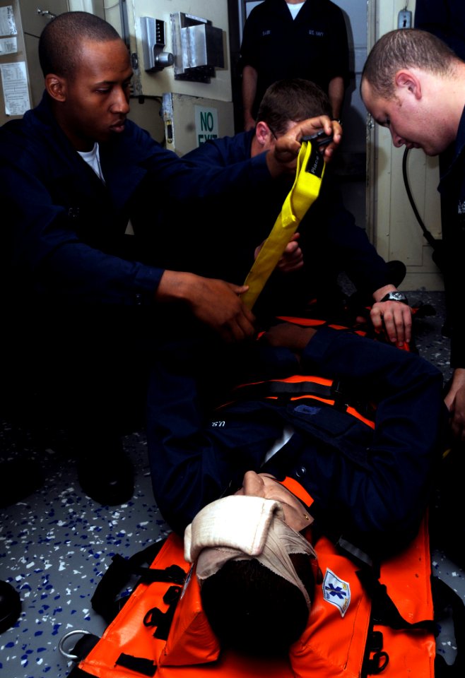 US Navy 081113-N-9758L-024 Sailors assigned to the Pearl Harbor-based Arleigh Burke-class guided-missile destroyer USS Paul Hamilton (DDG 60) strap down Yeoman Seaman Laquann Vines to a stretcher during a medical casualty drill