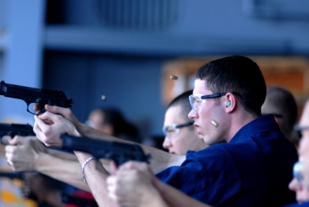 US Navy 081113-N-9132C-280 Aircrew Survival Equipmentman 3rd Class Robert Parker fires a 9mm pistol during live fire exercise aboard the Nimitz-class aircraft carrier USS Ronald Reagan (CVN 76)