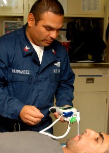 US Navy 081113-N-9134V-003 Hospital Corpsman 2nd Class Sergio Hernandez takes the temperature of an Iraqi Sailor photo