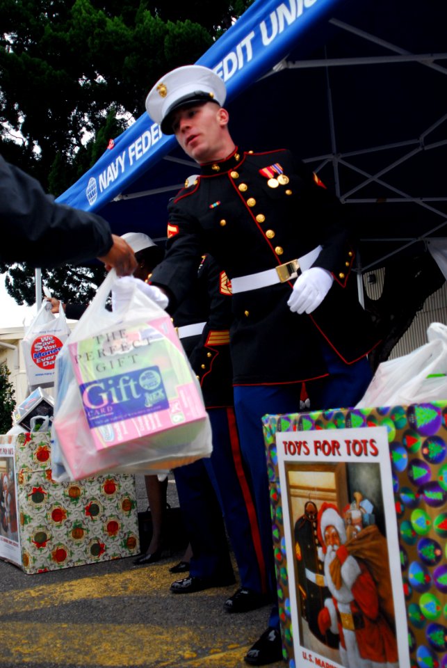 US Navy 081114-N-2013O-002 Lance Cpl. Samuel Joyce, from Boston, accepts a bagfull of toys during the Toys For Tots 5k Run at Fleet Activities Yokosuka. Runners donated new toys to the local Marine's Toys for Tots program