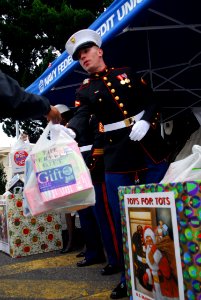 US Navy 081114-N-2013O-002 Lance Cpl. Samuel Joyce, from Boston, accepts a bagfull of toys during the Toys For Tots 5k Run at Fleet Activities Yokosuka. Runners donated new toys to the local Marine's Toys for Tots program