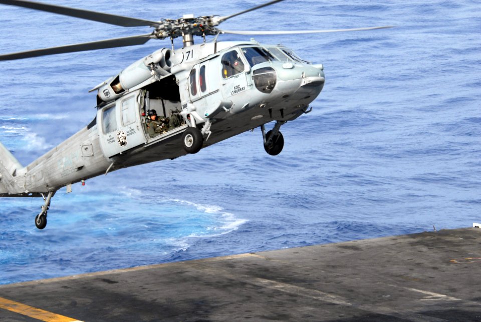 US Navy 081114-N-4995K-001 An aircrewman looks out the starboard door of an MH-60S Sea Hawk